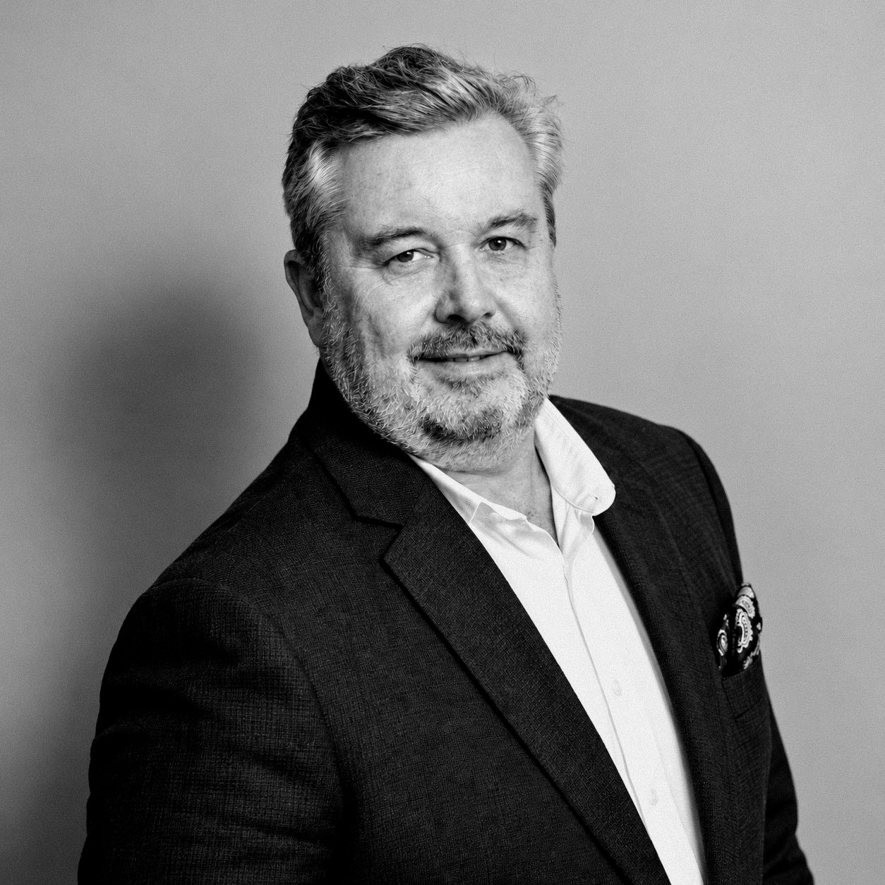 Andrew Mackenzie wearing a dark jacket and white shirt